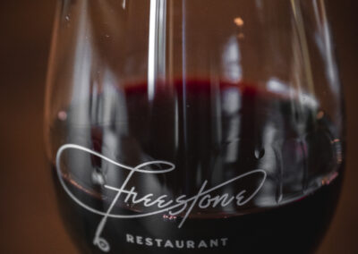 Glass of Red Wine photo with the Freestone Restaurant fly rod logo